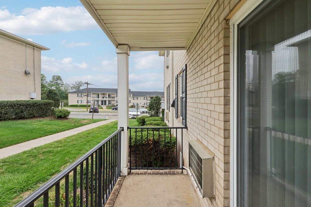 A balcony with a black railing and a glass door.