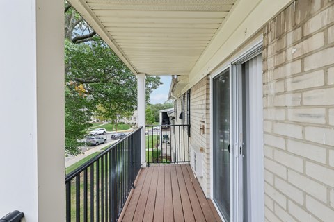 A balcony with a black railing and a glass door.