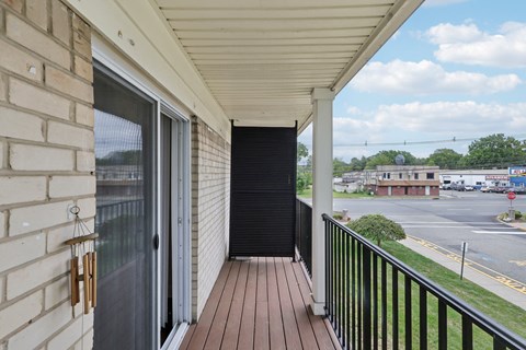 A balcony with a black railing and a view of a parking lot.