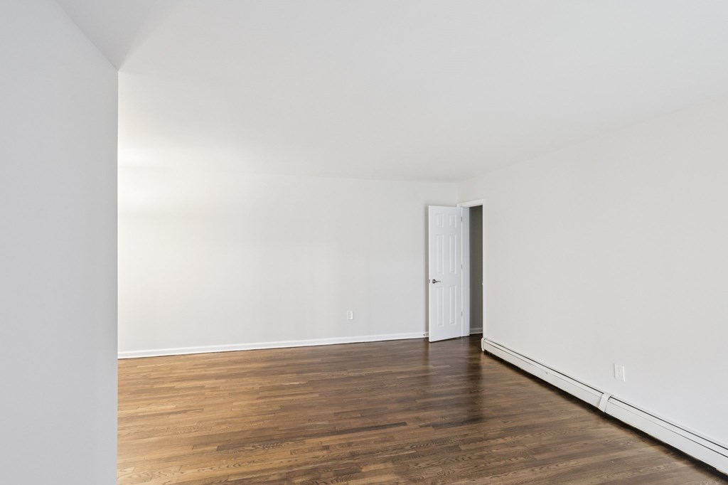 A room with a wooden floor and a white door.