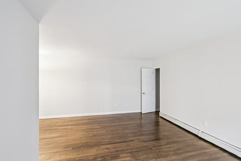 A room with a wooden floor and a white door.