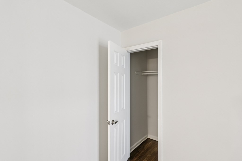 A white door is open to a small closet.