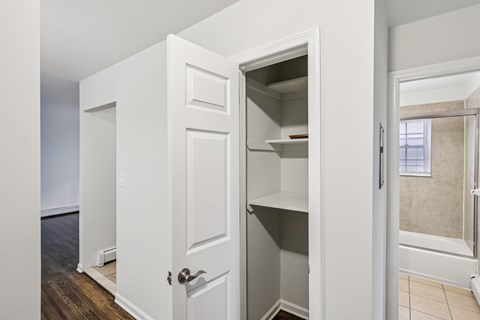 A white door with a shelf underneath it is open.