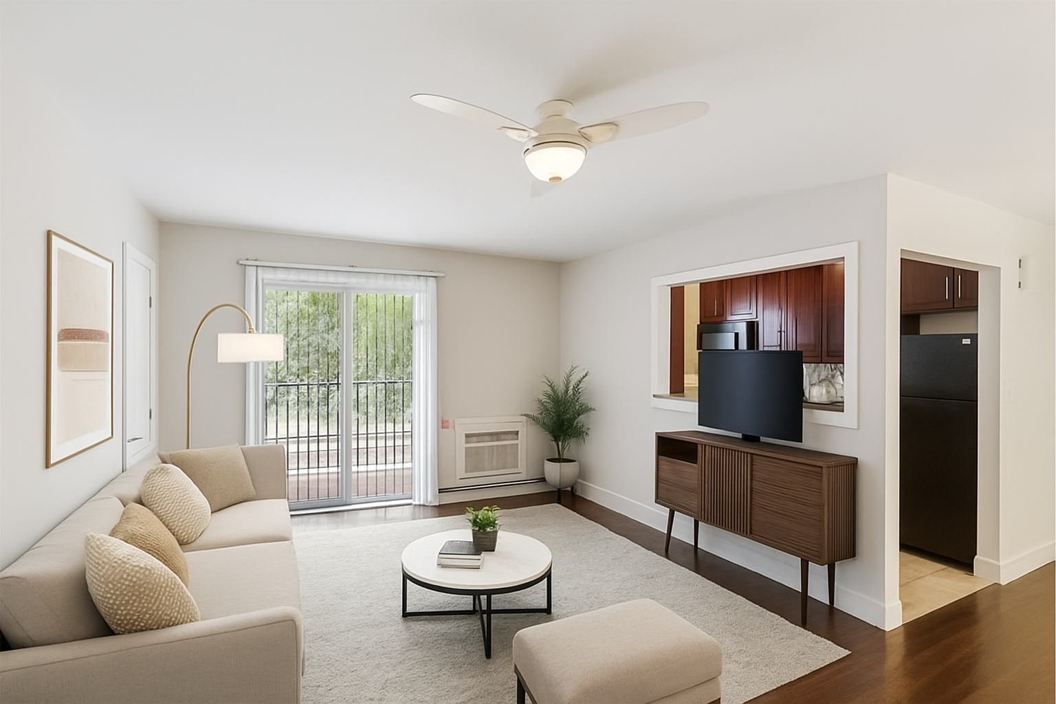 A living room with a couch, a coffee table, a television, and a ceiling fan.