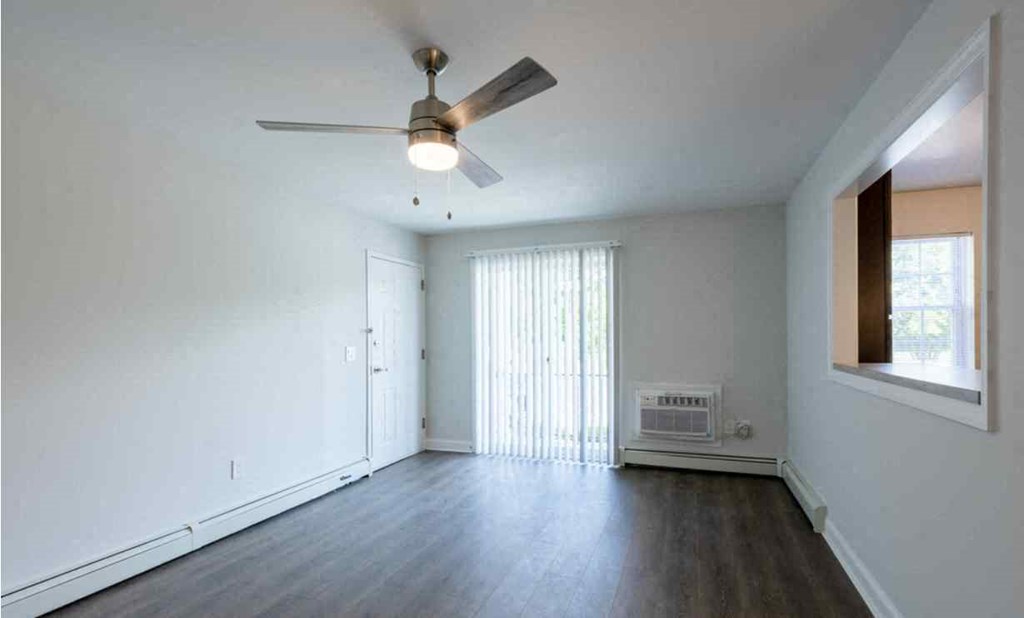 an empty living room with a ceiling fan