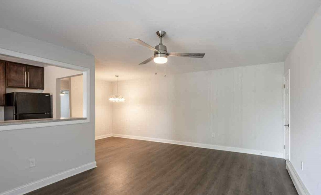 an empty living room with a ceiling fan