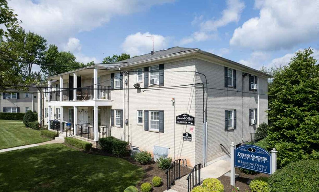 the front of a white building with a blue sign