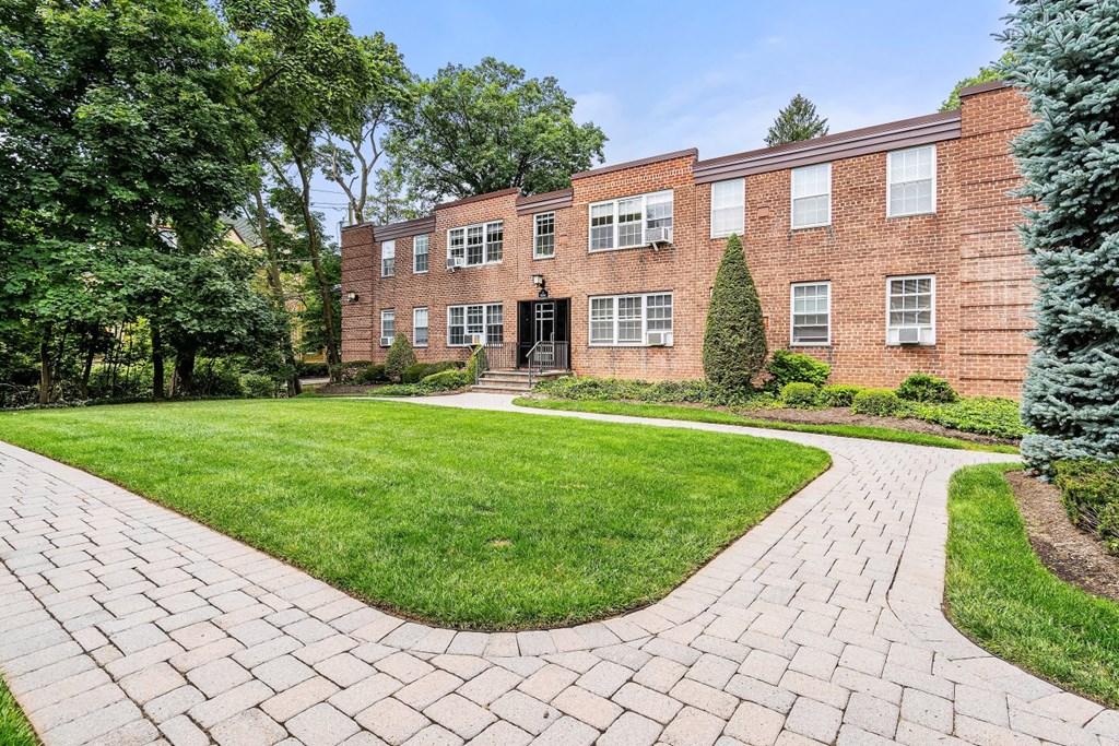 a brick building with a lawn in front of it