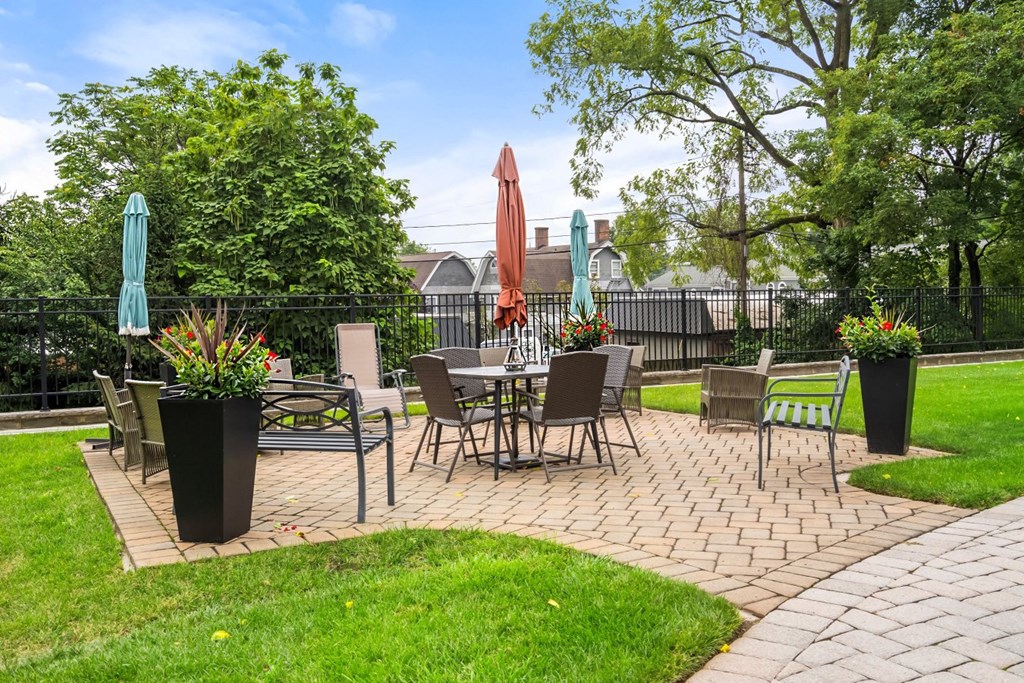 a patio with tables and chairs and a lawn