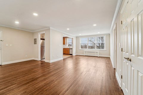 A spacious room with wooden floors and white walls.