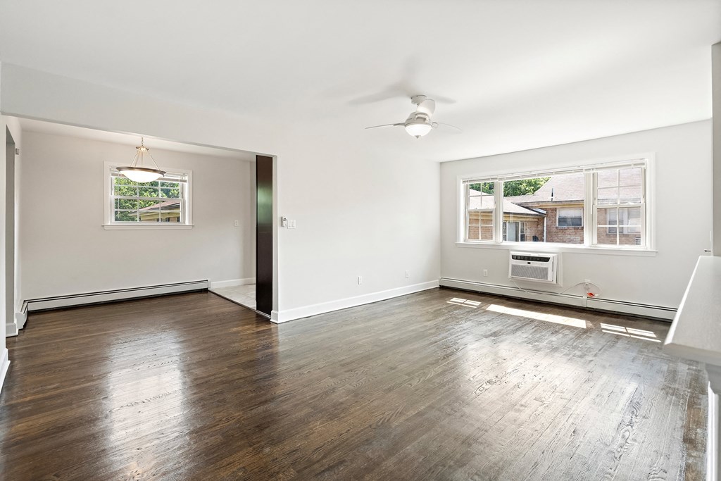 an empty living room with hardwood floors and a large window