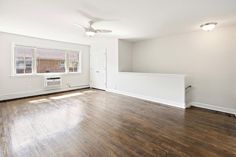 an empty living room with hardwood floors and a window