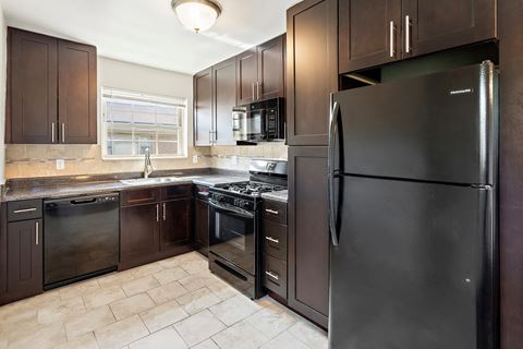 a kitchen with stainless steel appliances and dark wood cabinets
