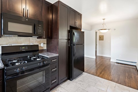 a kitchen with black appliances and dark wood cabinets