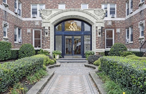 the front of a brick building with a blue door and a walkway in front