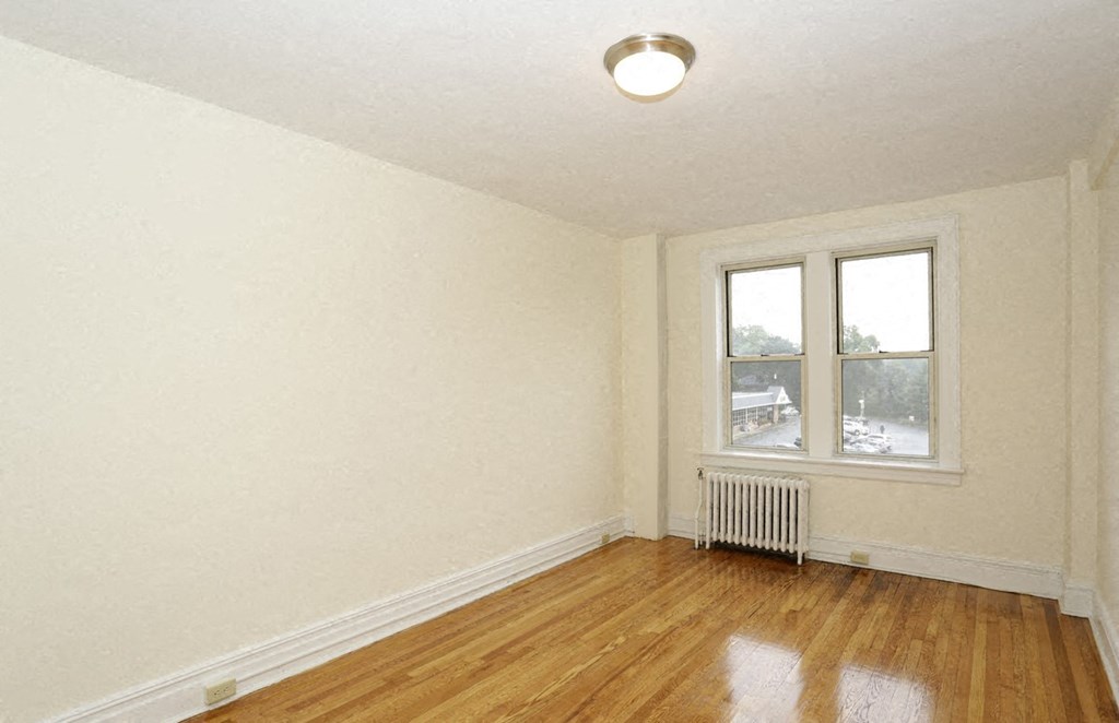 an empty room with a radiator and a window