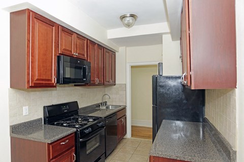 a kitchen with black appliances and wood cabinets