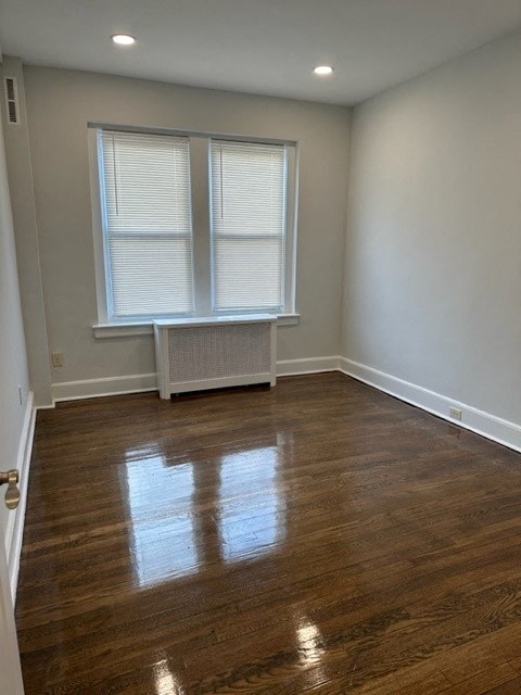 an empty room with wood floors and a window