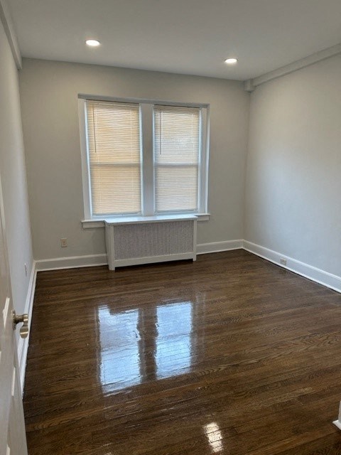 an empty room with a window and a wooden floor