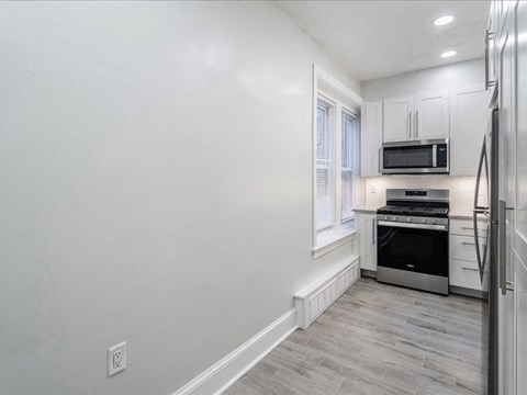 a white kitchen with a stove and a microwave