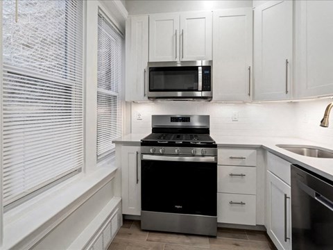 a kitchen with white cabinets and a stove and a microwave