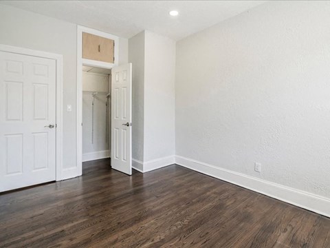 an empty living room with wood flooring and white walls