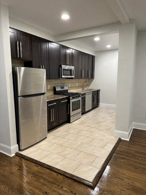 a kitchen with stainless steel appliances and black cabinets