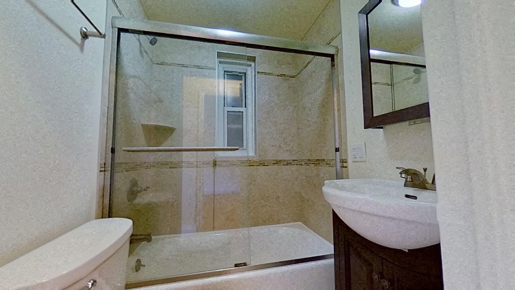 a bathroom with a shower and a sink and a toilet
