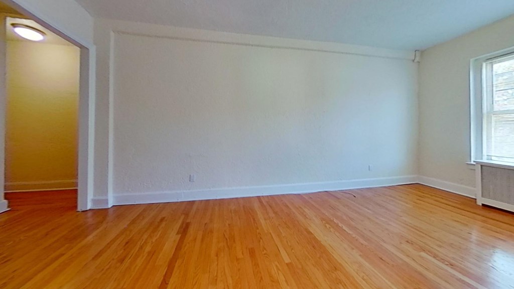 the living room of an empty house with wood floors