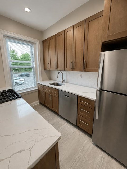 A kitchen with a marble counter top and stainless steel appliances.