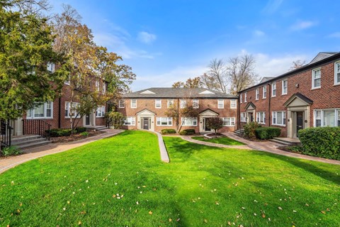a green lawn in front of a brick building