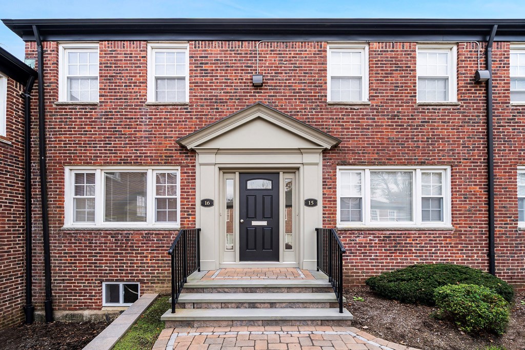 the front of a brick house with a black door