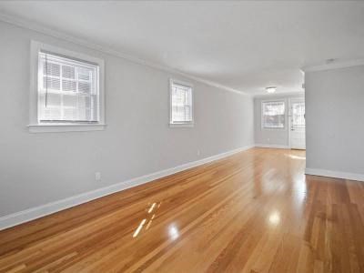 an empty living room with a hard wood floor