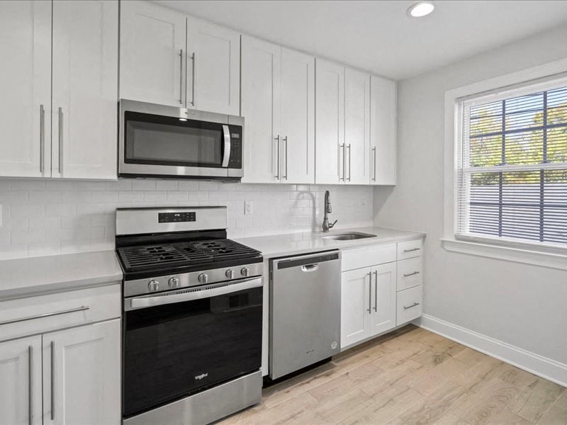 a kitchen with white cabinets and a stove and a microwave
