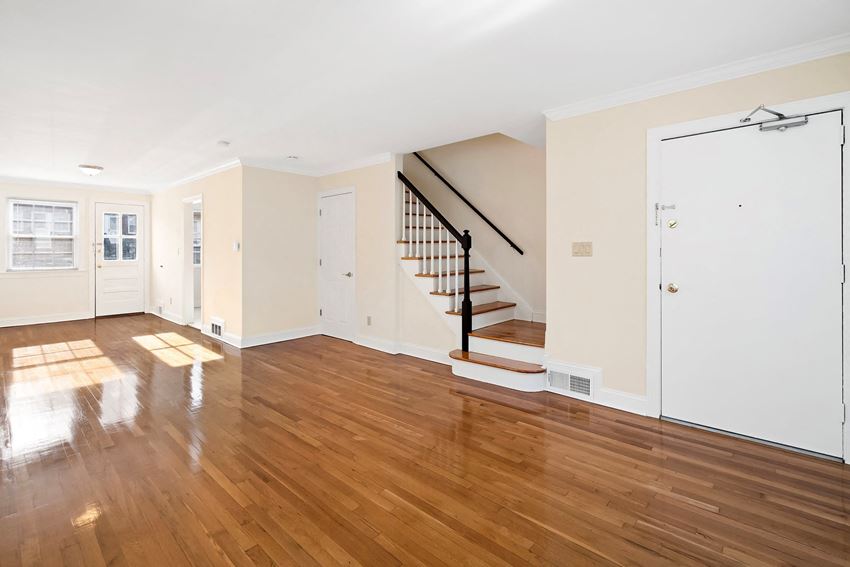 a living room with a staircase and a hard wood floor