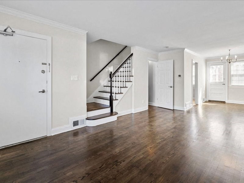 an empty living room with white walls and wooden floors
