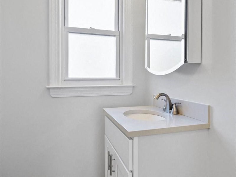 a white bathroom with a sink and a mirror