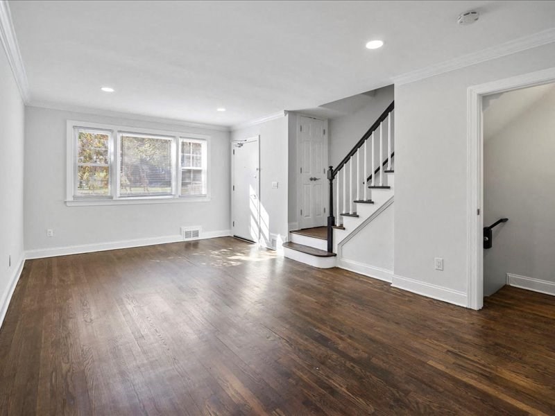 a living room with wood floors and a staircase