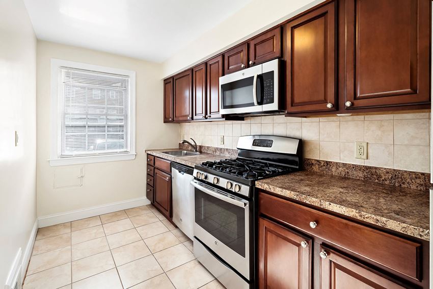 a kitchen with a stove and microwave and wooden cabinets