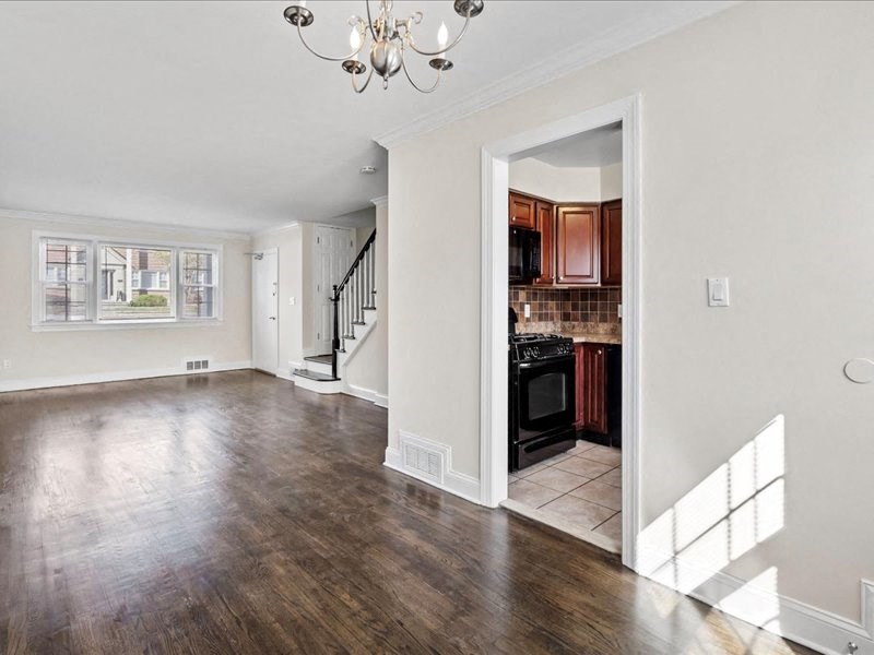 the living room and kitchen of an empty house with wood floors