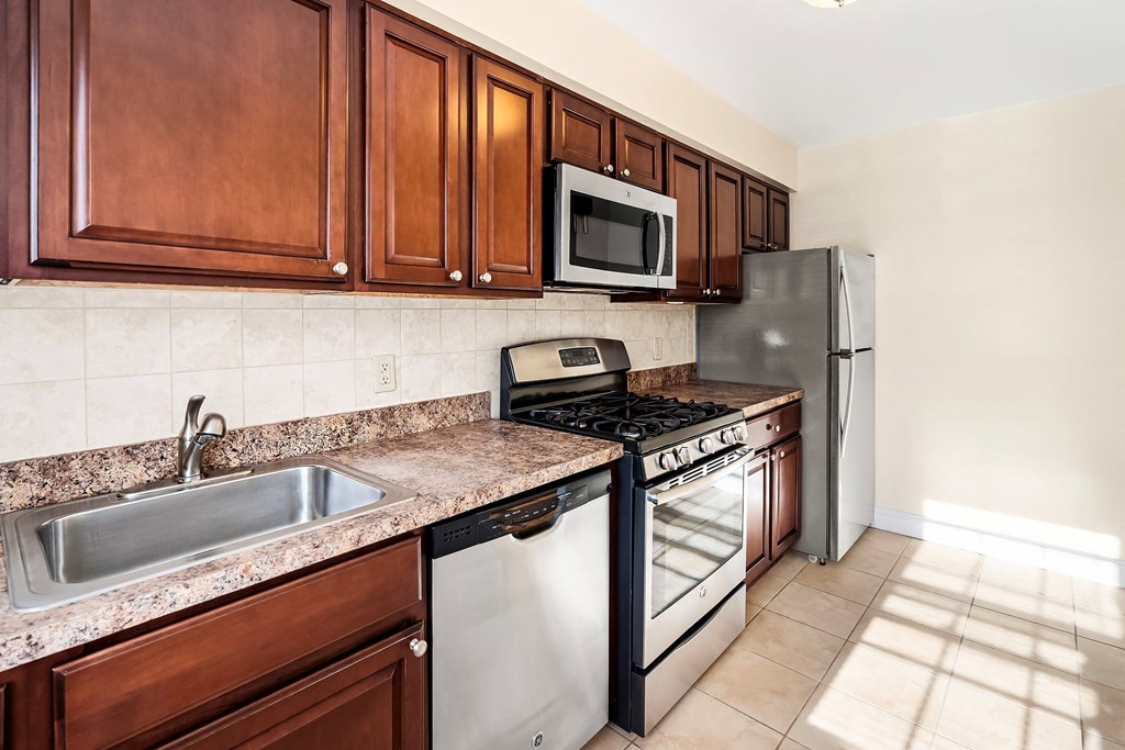 a kitchen with stainless steel appliances and wooden cabinets