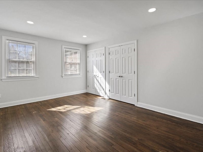 an empty living room with white walls and wood floors
