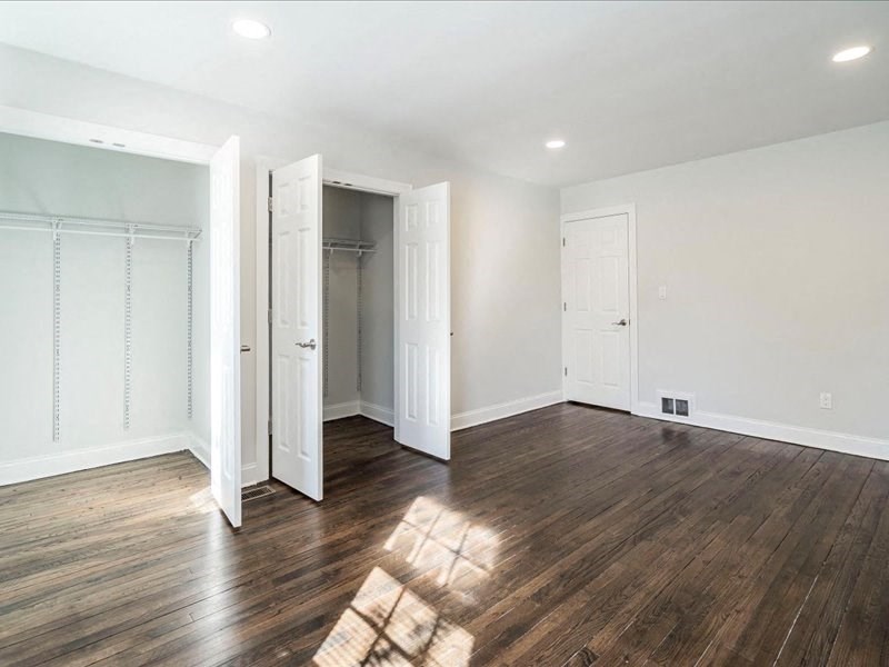 an empty living room with white walls and wood floors