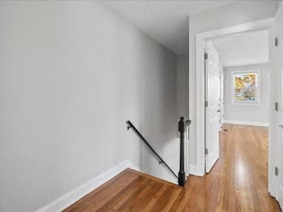 a white room with a wood floor and a staircase