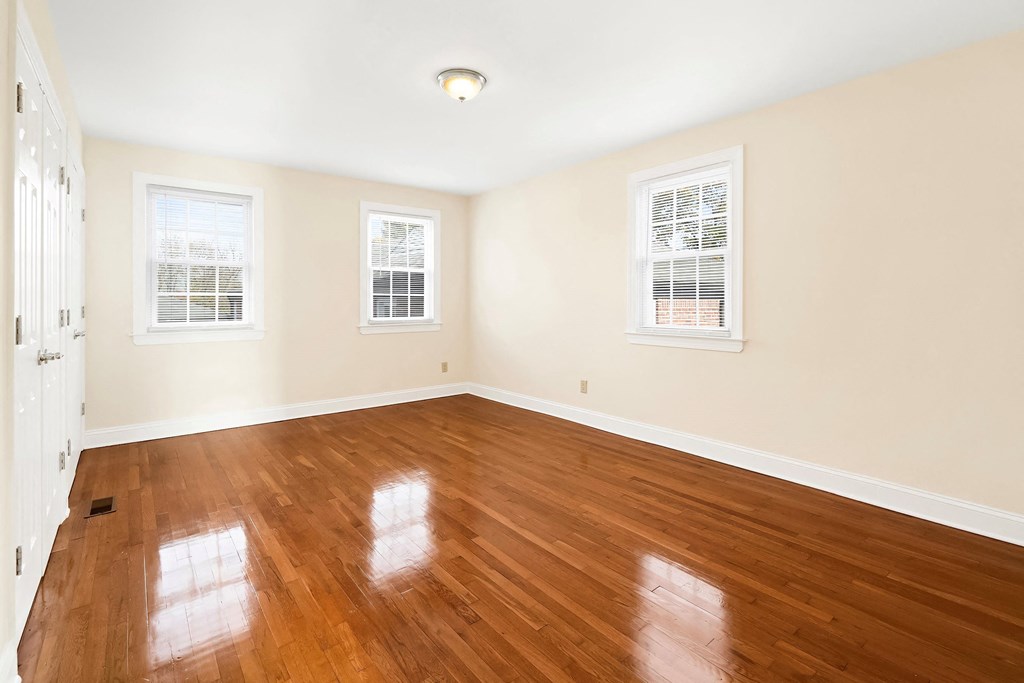 an empty living room with wood floors and white walls