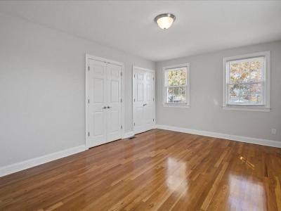an empty living room with white walls and a wooden floor