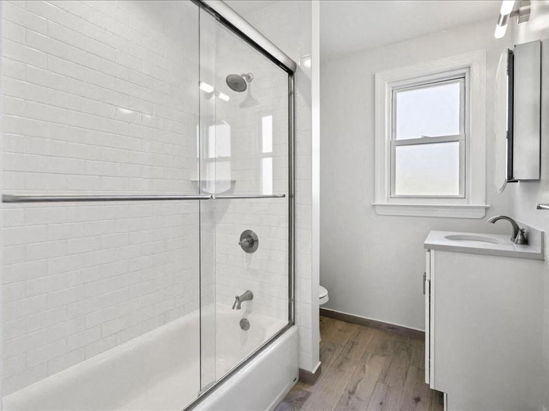 a white bathroom with a shower and a sink