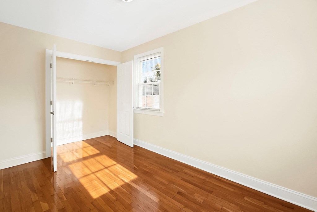 an empty room with wood floors and a window