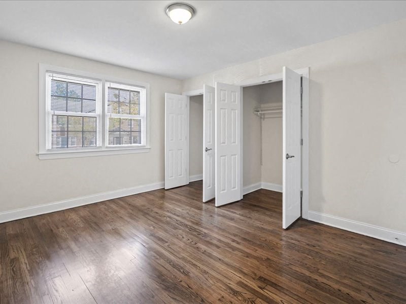 an empty living room with white walls and wood floors