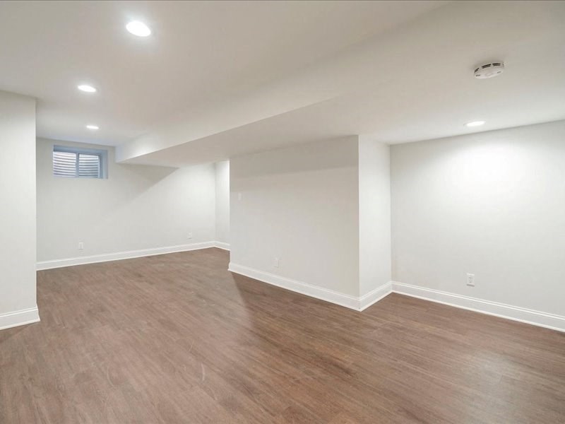 an empty living room with white walls and wood floors